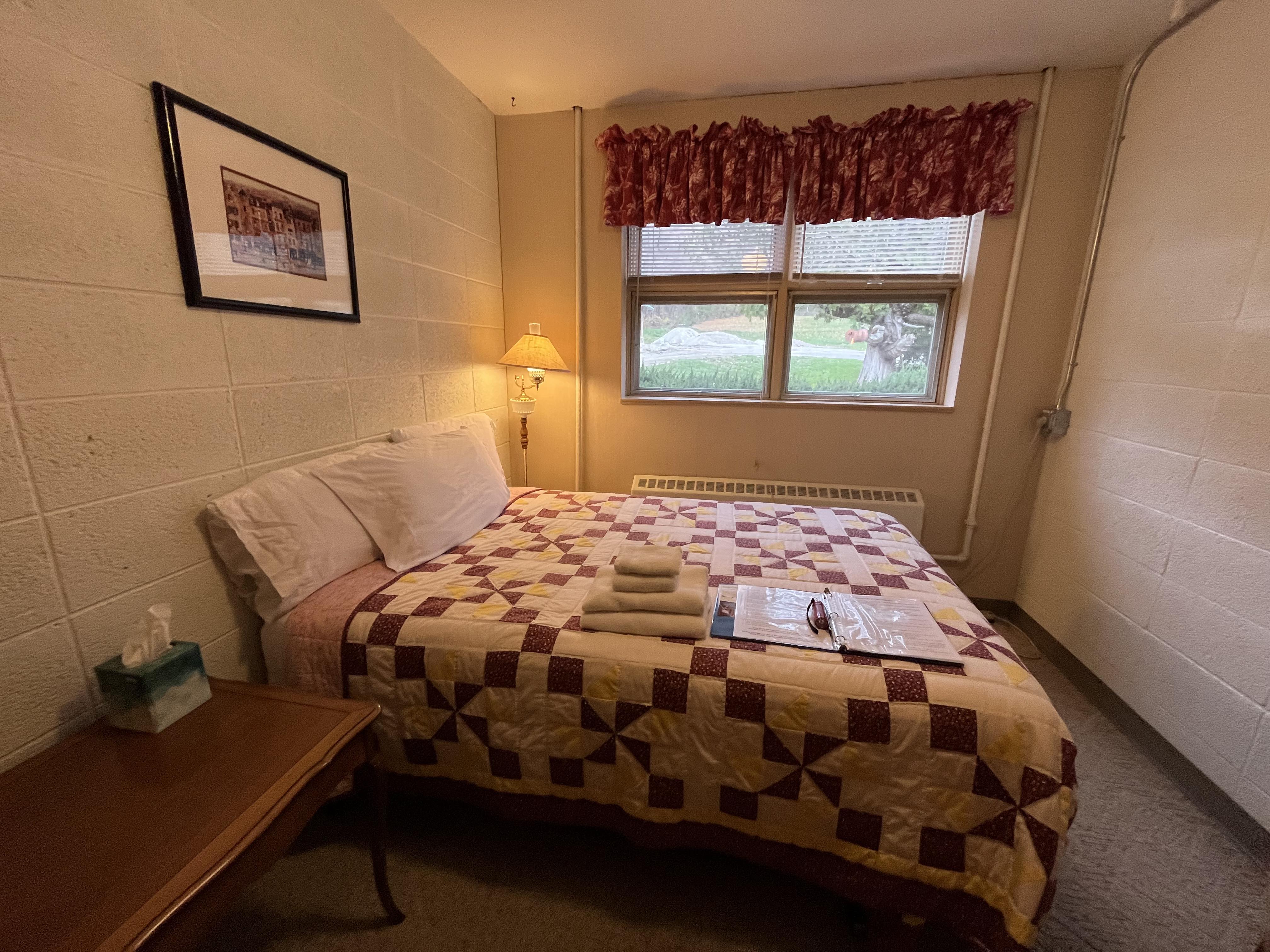 South Wing bedroom with quilt bedding and window view